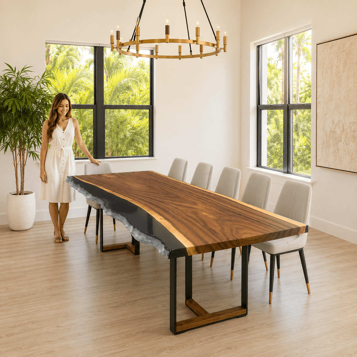 Woman standing next to a modern dining table in a bright room with large windows.